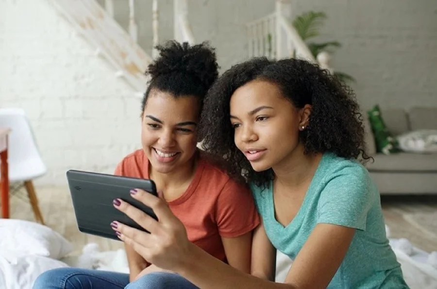 Two women reviewing healthcare savings options together on a tablet
