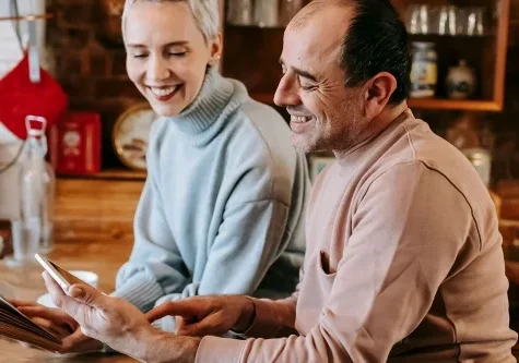 Two people reviewing documents together at a table while discussing Real Savings at home.