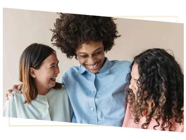 Three diverse women embracing and smiling together, representing friendship, support, and a strong commitment to long-term health care Three diverse women embracing and smiling together, representing friendship, support, and a strong commitment to long-term health care