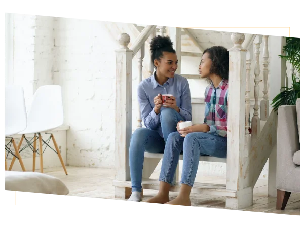 Two women discussing health insurance tips while reviewing their healthcare options at home. Two women discussing health insurance tips while reviewing their healthcare options at home.